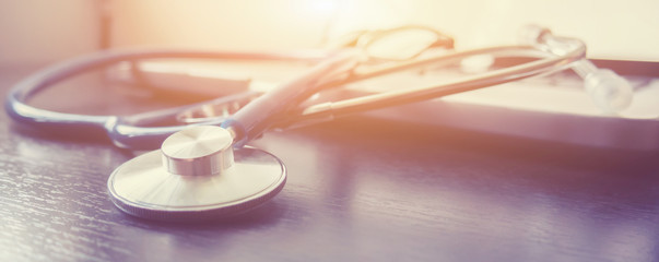 Stethoscope and laptop keyboard on desktop in hospital,relax time doctor,medical concept,selective focus,vintage color.morning light