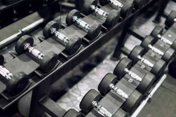 Gym and sports concept,Rows of dumbbells in the gyms with hign contrast,selective focus