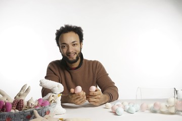 young African American bi-racial man with easter eggs and rabbits for easter. silly on white backgound