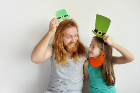 The father with the daughter try on masks for a St. Patrick's Day
