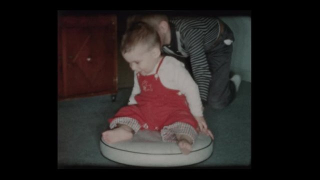 1960 Little boy pushes younger brother cushion top