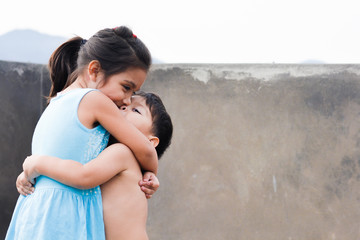 Little latin siblings hugging.