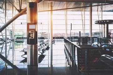 Deurstickers Luchthaven Payphone transparent cabin inside of contemporary airport terminal with empty screen mock-up above  interior of modern railway station with moving stairway, glass telephone booth, huge windows behind