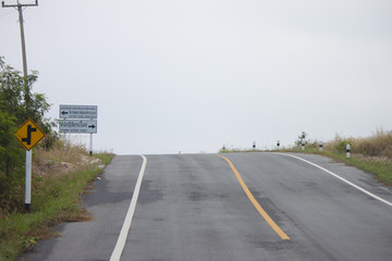 Road uphill slope background with fog on sky .