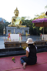 Thai woman respect praying and visit Golden big buddha statue in Amnat Charoen, Thailand