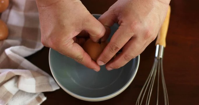 Close up chef hand braking an egg into a blue bowl then mix to prepare omelet cooking , 4k Dci resolution