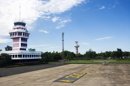Air Traffic Control tower and Small plane stop on runway at Ubon Ratchathani International Airport in Thailand