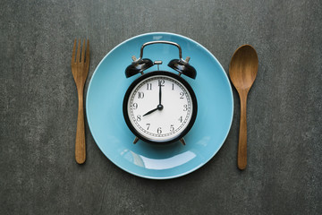 Food clock spoon and fork, Healthy food concept on black background