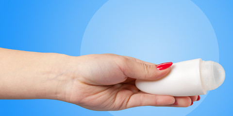Woman hand with a deodorant roll isolated on color background