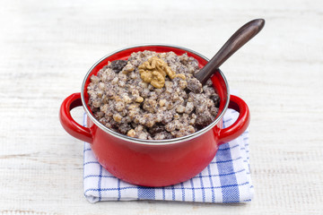 Red saucepan with kutia - traditional Christmas sweet meal in Ukraine, Belarus and Russia. Close up
