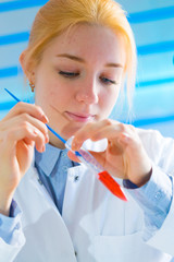 Laboratory assistant in the medical laboratory control a microbiological analysis of the blood. Using a pipette and a test tube in the laboratory