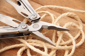 Multifunktionswerkzeug mit Seil auf einem Holzbrett