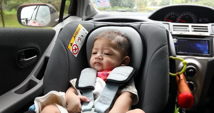 baby sitting in car seat of safety driving road trips