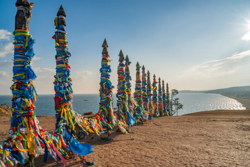 Sacred wooden columns with colourful ribbons, Baikal lake