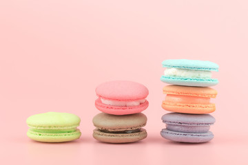 Sweet French macaroons cake (or macarons) with vintage pastel colored tone on pink background.