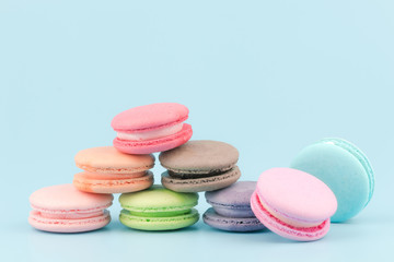 Sweet French macaroons cake (or macarons) with vintage pastel colored tone on blue background.