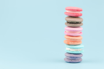 Sweet French macaroons cake (or macarons) with vintage pastel colored tone on blue background.