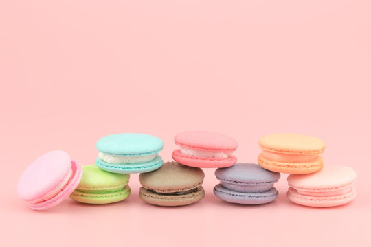 Sweet French macaroons cake (or macarons) with vintage pastel colored tone on pink background.