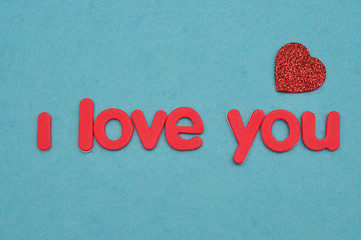 I love you in red letters on a blue background with a red heart