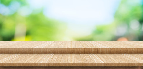 Empty step wood table top food stand with blur green park tree background bokeh light,Mock up for display or montage of product,Banner for advertise on online media,nature business presentation