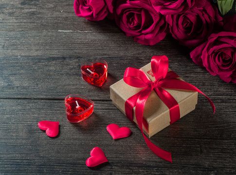 Valentine's day background, roses and gifts on a wooden board