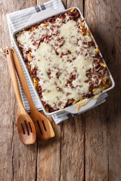 Delicious and hearty meal: million dollars pasta casserole in a baking dish close-up on the table. vertical top view