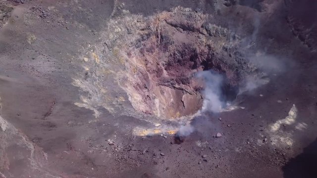 Aerial view of the edge of a smoked and active crater. 4k
