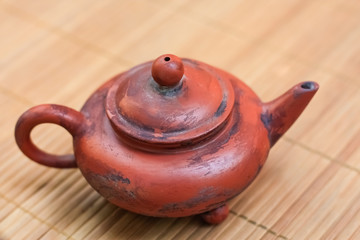 old brown ceramic teapot on bamboo Mat.