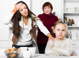 Frustrated girl while mother and grandmother berating her