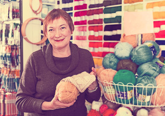 Fototapeta premium Woman picking yarn in shop