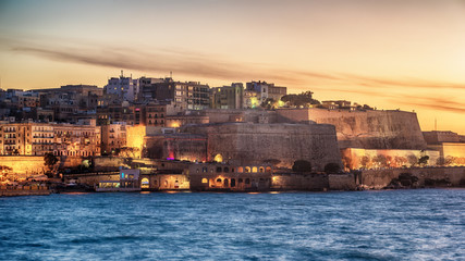 Fototapeta premium Malta: city walls of Valletta and Marsans Harbour at sunset
