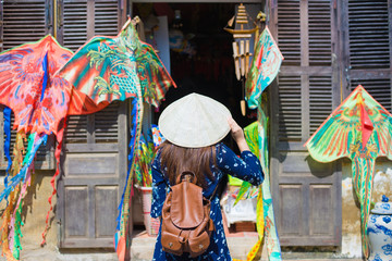 Fototapeta na wymiar Tourist woman is wearing Non La (Vietnamese tradition hat) and enjoy sightseeing at Heritage village in Hoi An city in Vietnam.