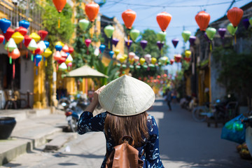 Tourist woman is wearing Non La (Vietnamese tradition hat) and enjoy sightseeing at Heritage...