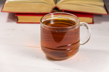 Cup of tea and book on white wooden table