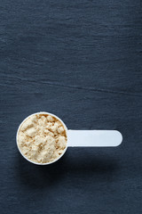 Protein powder scoop against slate background