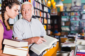 Positive grandfather with girl are reading books