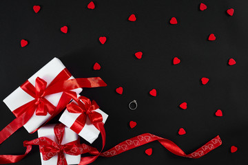 White gift boxes with red ribbon on black background. Valentines