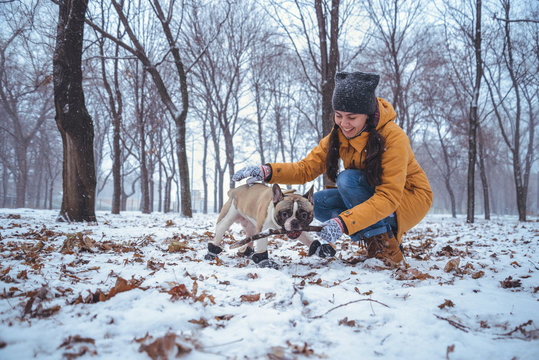 woman playing with french bulldog