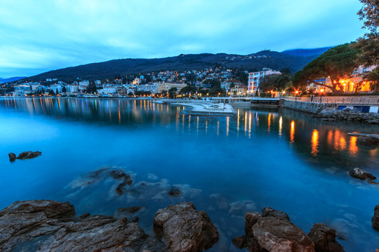 Lights of the Croatian costal city Opatija reflecting in the sea on  the winter morning