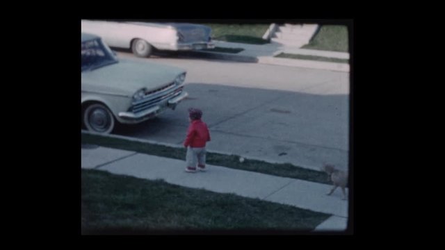 1960 Little boy gets out of antique car trips and falls down