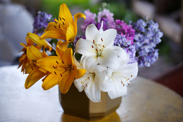 Bouquet of yellow and white lilies and lilac.