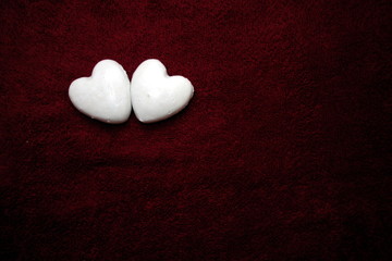 Obraz premium Valentine`s day concept with two hearts together on dark red background