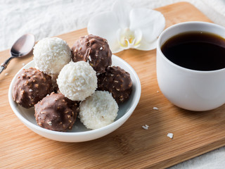 Chocolate and Coconut Candies in a Bowl on a Wooden tray Coffee Cup Orchid.
