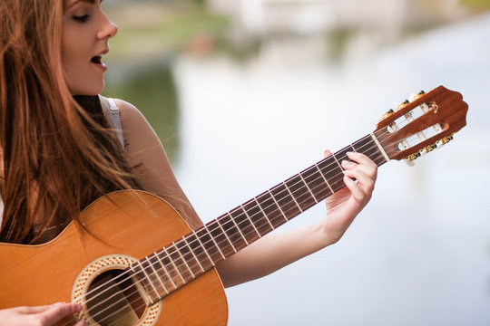 Guitar romantic city musician performance. woman playing stringed instrument and singing. Lifestyle of talented people.