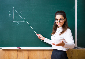 a young teacher explains math near the board