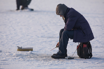 Fototapeta na wymiar winter fishing, hole on the lake, fisherman