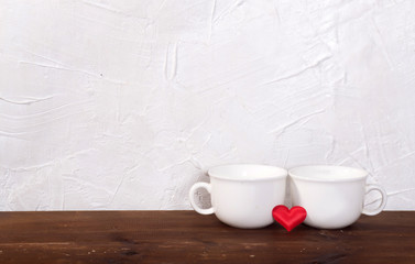 Valentine's day holiday celebration with hearts and cups over bokeh background