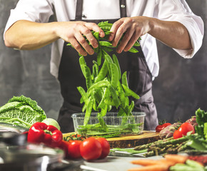 Chefkoch in der Küche mit Frischem Gemüse(Zuckererbsen)