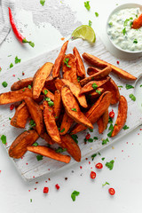 Healthy Homemade Baked Orange Sweet Potato wedges with fresh cream dip sauce, herbs, salt and pepper.