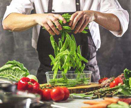Chefkoch in der K&uuml;che mit Frischem Gem&uuml;se(Zuckererbsen)